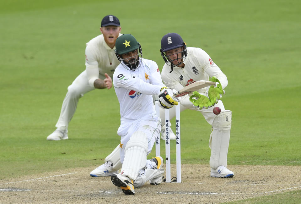 Pakistan's Shadab Khan, center, plays a shot during the second day of the first cricket Test match between England and Pakistan at Old Trafford in Manchester, England, Thursday, Aug. 6, 2020. (Dan Mullan/Pool via AP)