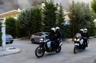 Policemen on motorcycles patrol during an evacuation of Adames area, northern Athens, Greece, Tuesday, Aug. 3, 2021. Hundreds of residents living near a forest area north of Athens fled their homes Tuesday as a wildfire reached residential areas as Greece grappled with its worst heatwave in decades. (AP Photo/Michael Varaklas)