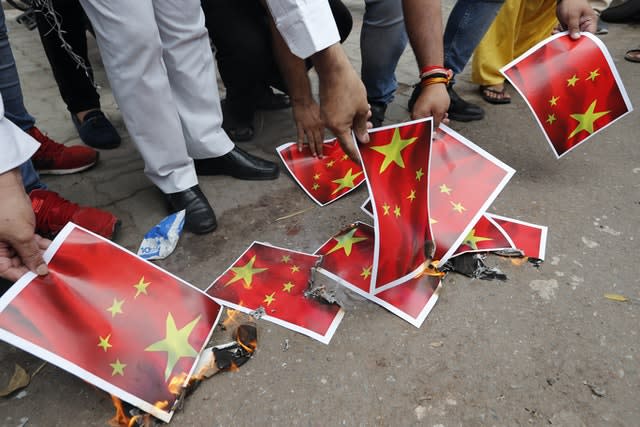 Indians burn posters of the Chinese national flag (Rajesh Kumar Singh/AP)