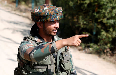 An Indian army soldier gestures as he tries to keep the media away from the site of a gunbattle near a security camp in which Indian authorities say suspected militants are holed up, on the outskirts of Srinagar, October 3, 2017. REUTERS/Danish Ismail