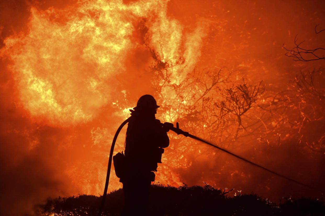 The Saddleridge fire flares up near a firefighter in Sylmar, Calif., Thursday, Oct. 10, 2019. (Photo: Michael Owen Baker/AP)