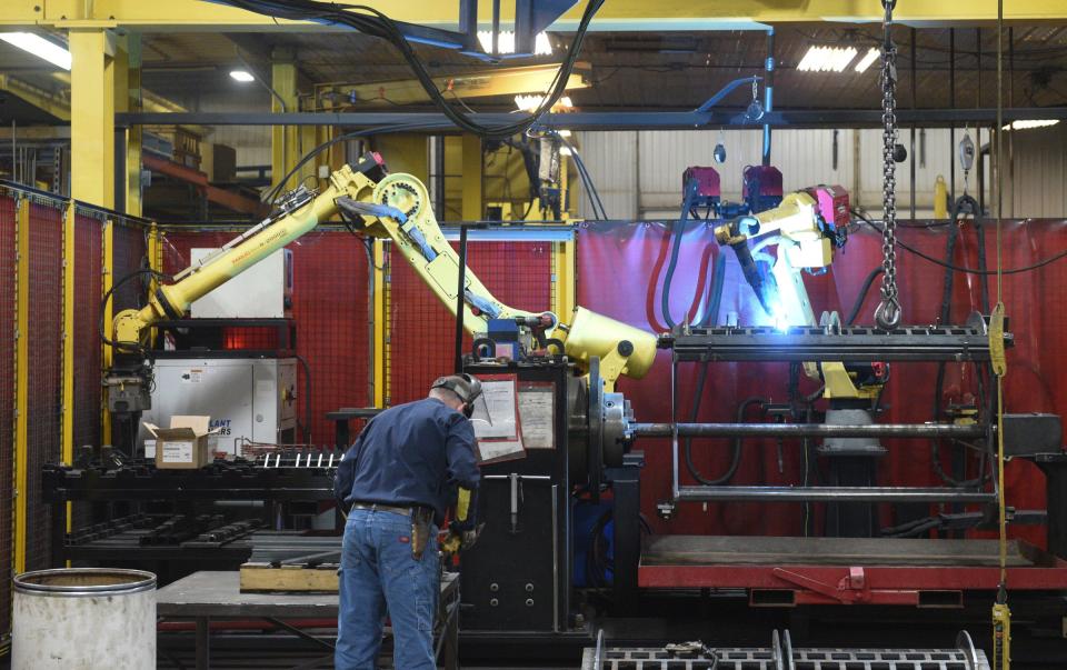 Robots and employees work together in the Rotochopper manufacturing facility Tuesday, April 13, 2021, in St. Martin.