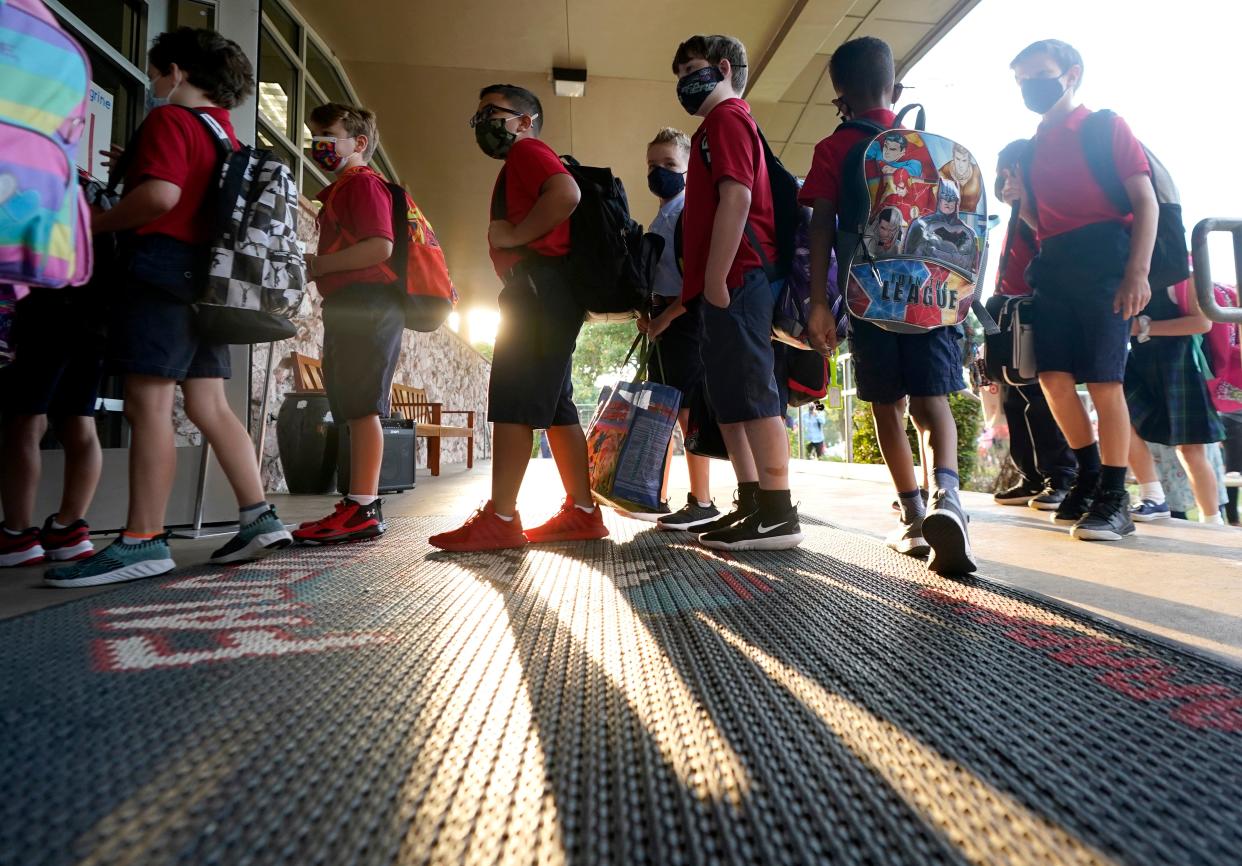 Children wearing masks enter a school in Texas.  (AP)