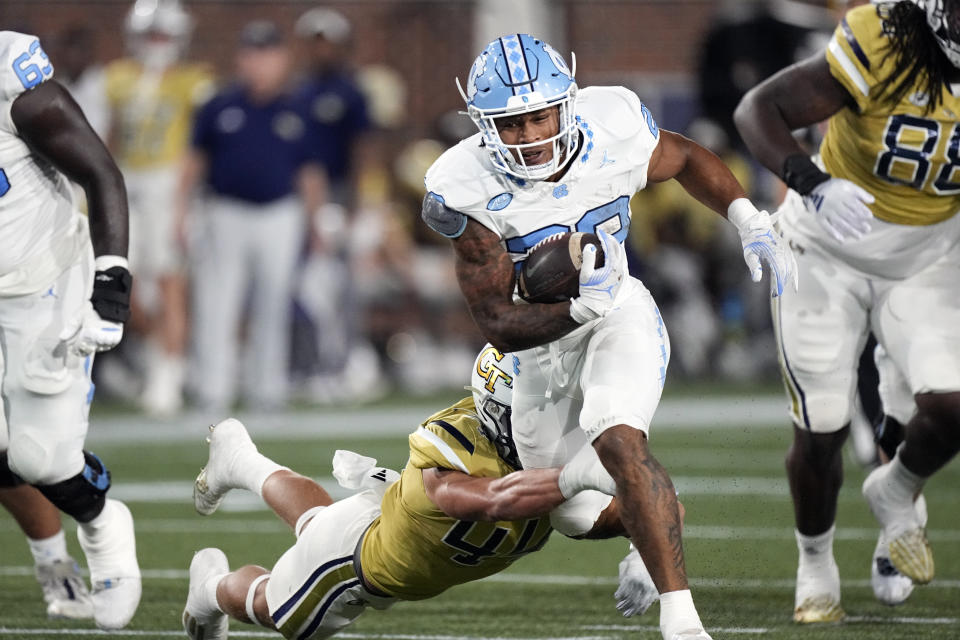 North Carolina running back Omarion Hampton (28) tries to escape from Georgia Tech linebacker Kyle Efford (44) during the first half of an NCAA college football game, Saturday, Oct. 28, 2023, in Atlanta. (AP Photo/John Bzemore)