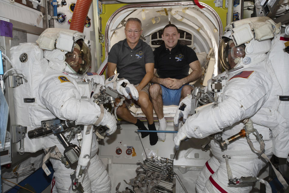 In this June 26, 2020 photo made available by NASA, spacewalkers Bob Behnken, foreground left, and Chris Cassidy, foreground right, are suited up with assistance from Expedition 63 Flight Engineers Doug Hurley, center left, and Ivan Vagner in the International Space Station. On Wednesday, July 29, 2020, SpaceX and NASA cleared the Dragon crew capsule to depart the International Space Station and head home after a two-month flight. (NASA via AP)