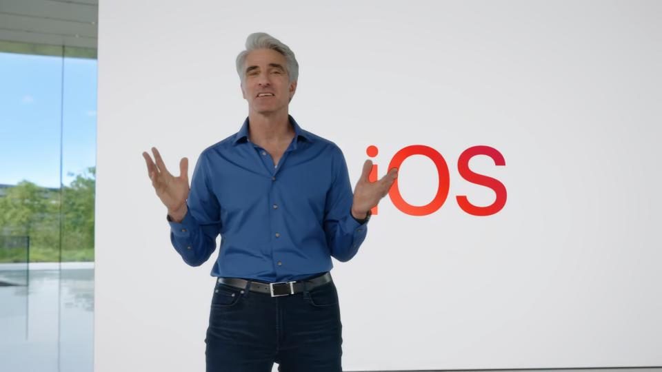 El vicepresidente de Apple, Craig Federighi, en el evento principal de la WWDC.  Se encuentra dentro del Apple Park, frente a una enorme pizarra con algo escrito. 