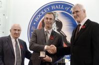 Scott Niedermayer receives his Hall of Fame ring from selection committee chair Jim Gregory, left, and Hall of Fame chair Pat Quinn, right.