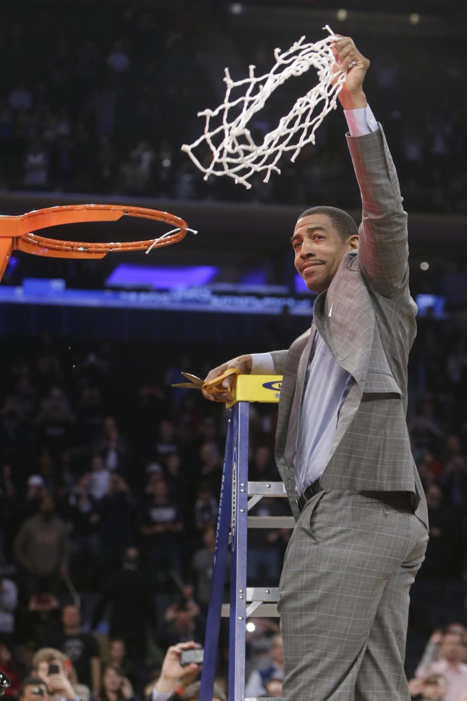 Connecticut head coach Kevin Ollie displays the net to the crowd after cutting it down after the regional final against Michigan State in the NCAA college basketball tournament Sunday, March 30, 2014, in New York. Connecticut won 60-54. (AP Photo/Frank Franklin II)