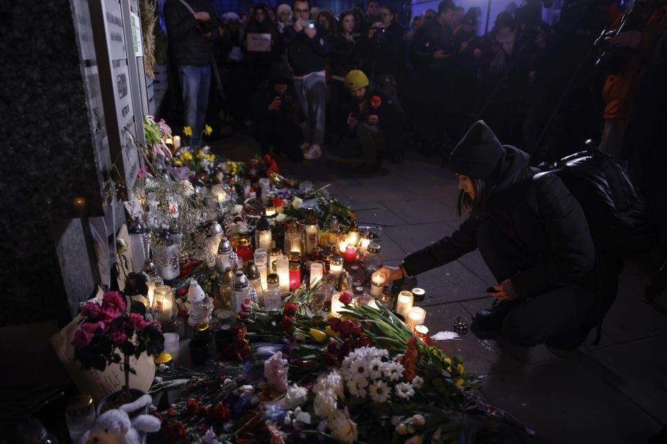 A woman lights a candle during a march in silence to commemorate Lizaveta, a 25-year-old Belarusian woman who died after a being brutally attacked and raped on the streets of Warsaw last month, in Warsaw Poland, Wednesday, March 6, 2024. The crime has shocked people across Poland. Poles, Belarusians and Ukrainians gathered at the site of the crime in downtown Warsaw, placing flowers and lighting candles in honor of the woman known only as Lizaveta, or Liza. (AP Photo/Michal Dyjuk)