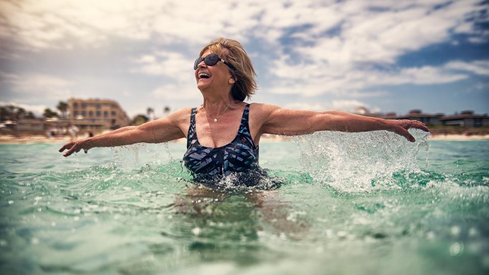 Happy senior woman enjoying summer beach vacations.