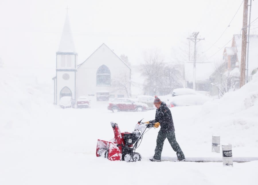 J.J. Morgan clears snow on Church Street near the historic Truckee Hotel as snow continues to fall in downtown Truckee, Calif., Sunday, March 3, 2024. (Jane Tyska/Bay Area News Group via AP)