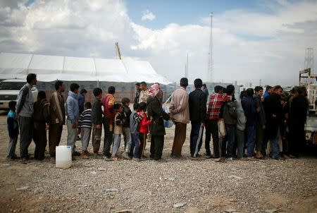 Displaced Iraqis who had fled their homes wait to get food supplies before entering at Hammam al-Alil camp south of Mosul, Iraq April 3, 2017. REUTERS/Suhaib Salem