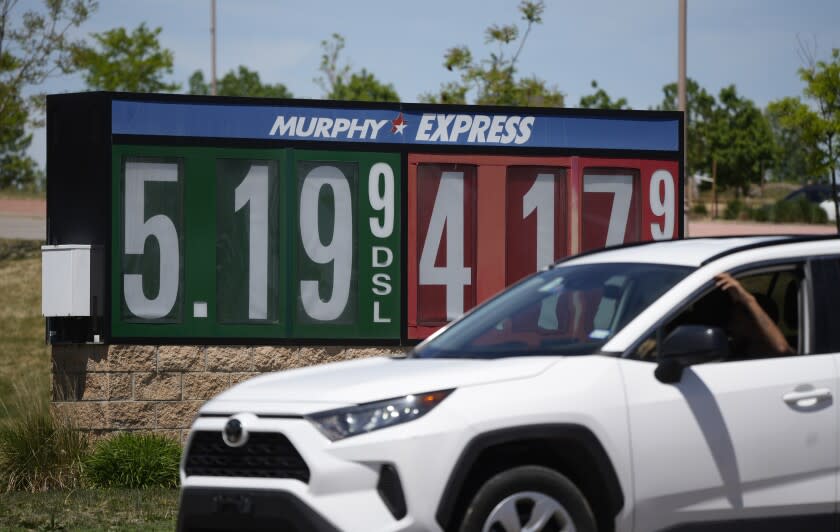 Gasoline prices are displayed outside a convenience store as a motorist drives by, Thursday, May 26, 2022, in Thornton, Colo. Experts are expecting a flush of travelers at airports and on the nation's byways during the long Memorial Day weekend, which marks the start of the summer travel season, in spite of high fuel costs. (AP Photo/David Zalubowski)