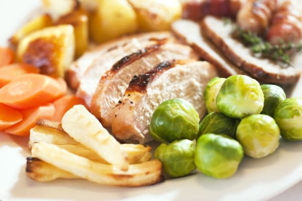 Christmas turkey dinner with Brussels sprouts, parsnips, carrots, roast potatoes, stuffing and pigs in blankets (sausages wrappe