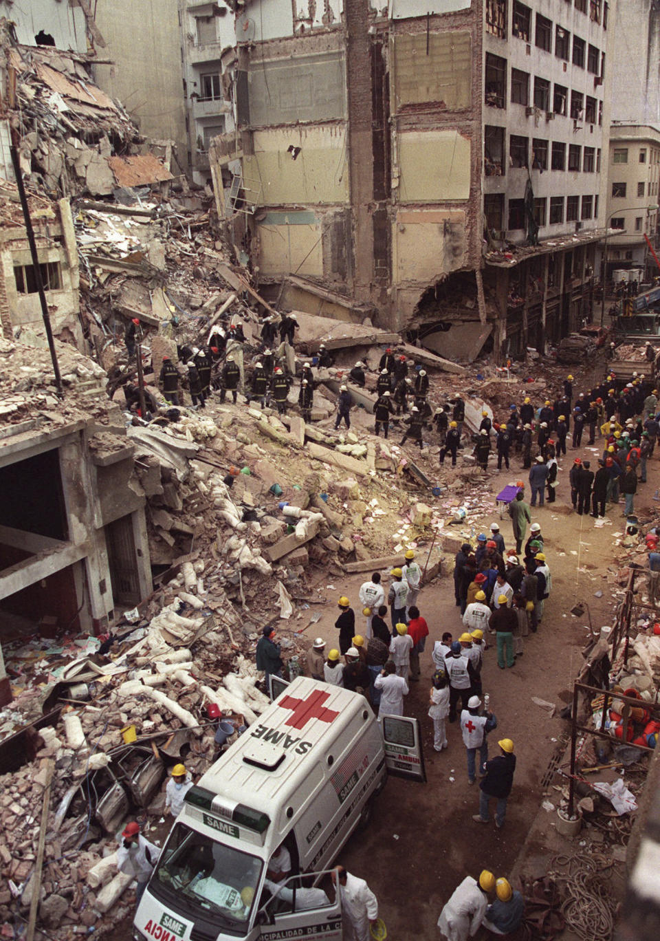 ARCHIVO - Bomberos y rescatistas buscan entre los escombros del Centro de la Comunidad Judía de Buenos Aires, tras la explosión de un coche bomba que derrumbó el edificio el 18 de julio de 1994. Fue el peor ataque de la historia de Argentina, que dejó 85 muertos y 300 heridos. Sucedió dos años después de otra explosión en 1992 en la embajada de Israel en Argentina, que mató a 22 personas. (AP Foto/Alejandro Pagni, Archivo)