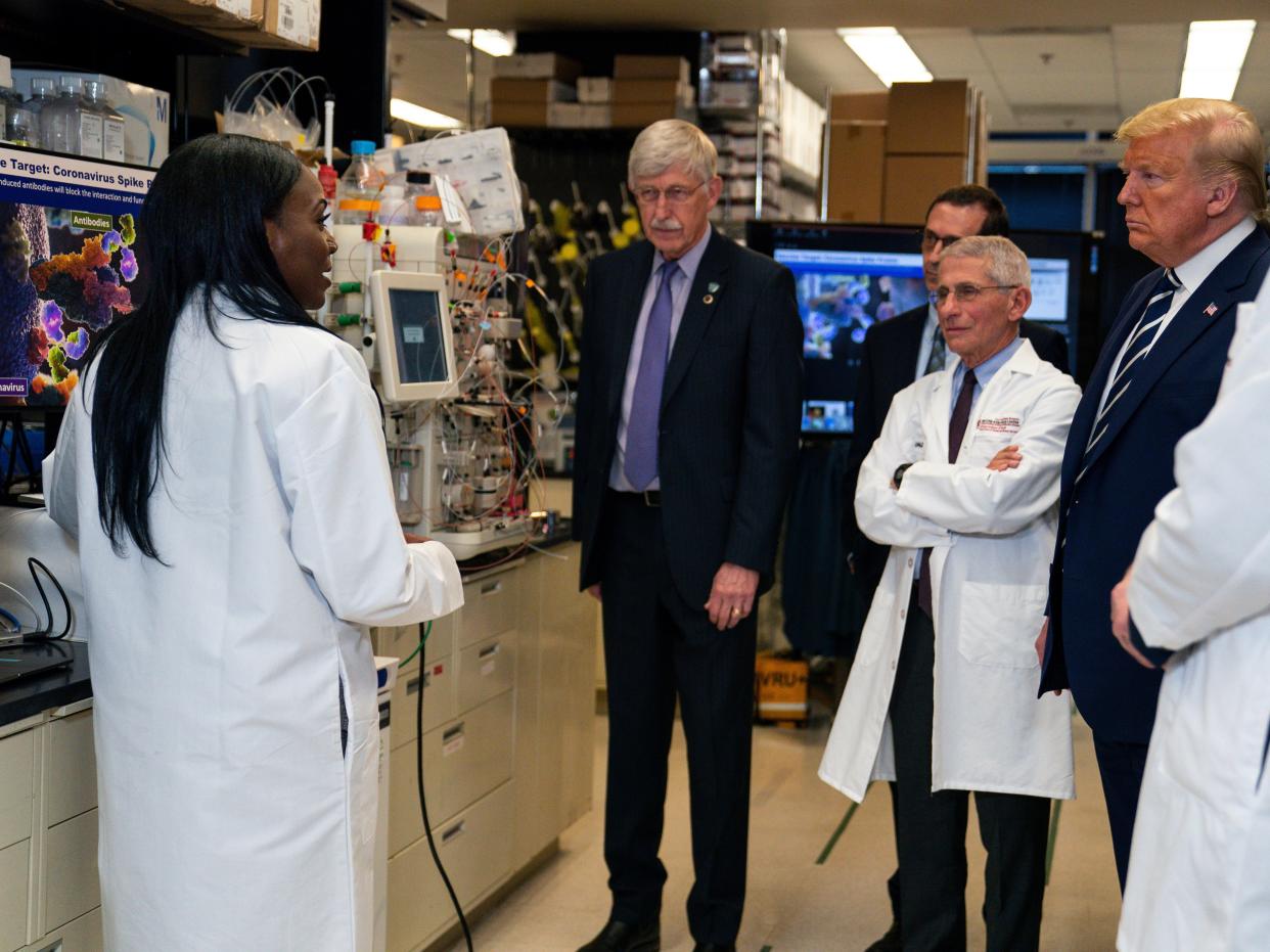 FILE - In this Tuesday, March 3, 2020 file photo, Dr. Kizzmekia Corbett, left, senior research fellow and scientific lead for coronavirus vaccines and immunopathogenesis team in the Viral Pathogenesis Laboratory, talks with President Donald Trump as he tours the Viral Pathogenesis Laboratory at the National Institutes of Health in Bethesda, Md. Dozens of research groups around the world are racing to create a vaccine as COVID-19 cases continue to grow. (AP Photo/Evan Vucci)