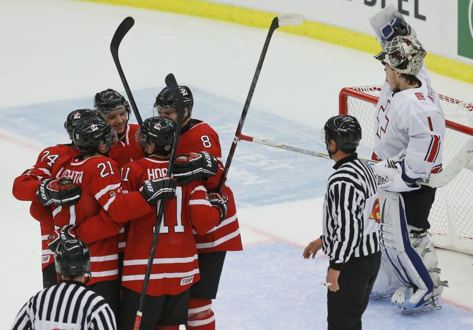 Canada celebrates a goal by Griffin Reinhart (8) in front of Switzerland's goalie Melvin Nyffeler during the first period of their IIHF World Junior Championship ice hockey game in Malmo, Sweden, January 2, 2014. REUTERS/Alexander Demianchuk (SWEDEN - Tags: SPORT ICE HOCKEY)