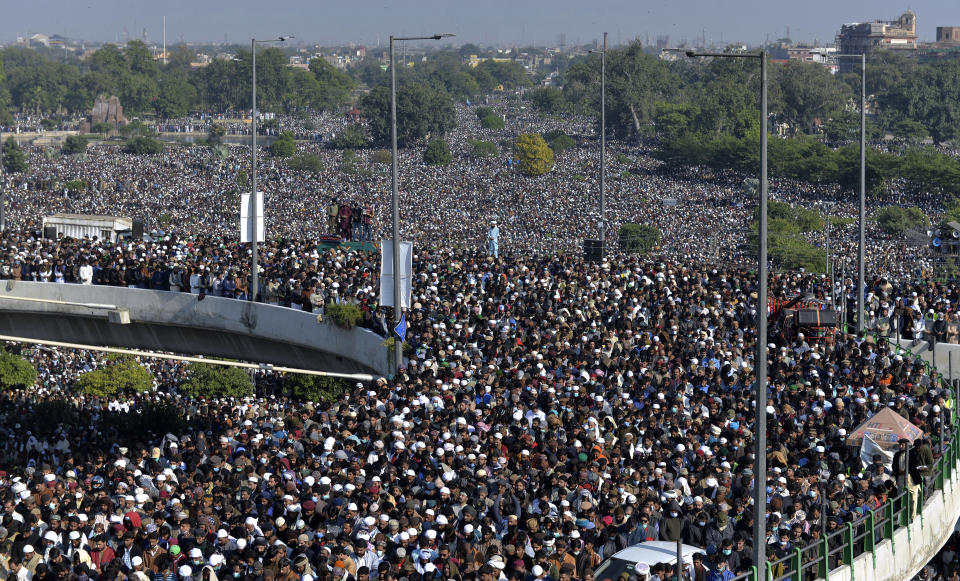 Mourners gather for the funeral prayer of Khadim Hussein Rizvi, an Islamist scholar and leader of Tehreek-e-Labiak Pakistan, in Lahore, Pakistan, Saturday, Nov. 21, 2020. Tens of thousands of mourners on Saturday thronged the funeral of the radical cleric whose Islamist party has defended Pakistan's controversial blasphemy law that calls for the death penalty for insulting Islam. (AP Photo/Waleed Ahmed)