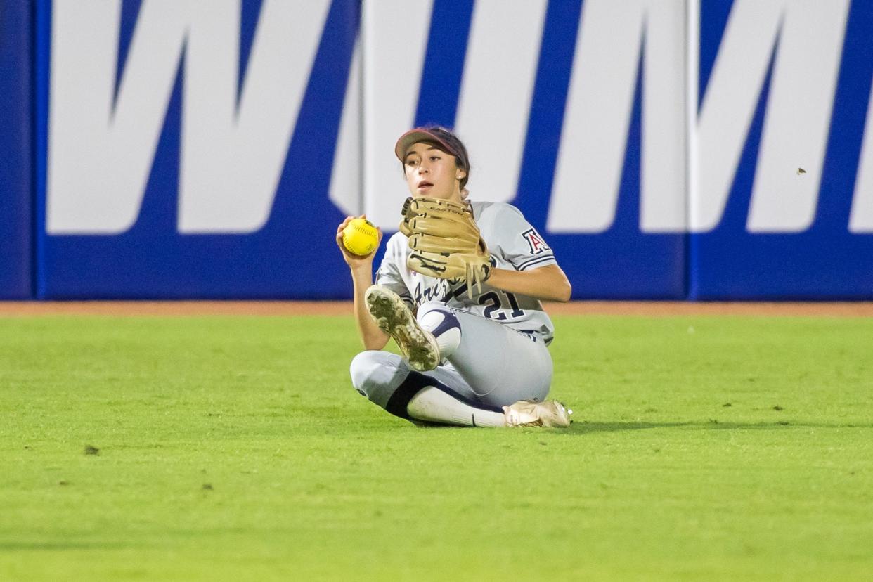 Jun 3, 2022; Oklahoma City, Oklahoma, USA;  Arizona Wildcats left fielder Jasmine Perezchica (21) makes a sliding catch to end the game during the seventh inning of the NCAA Women's College World Series game against the Oregon State Beavers at USA Softball Hall of Fame Stadium. Arizona won 3-1. Mandatory Credit: Brett Rojo-USA TODAY Sports