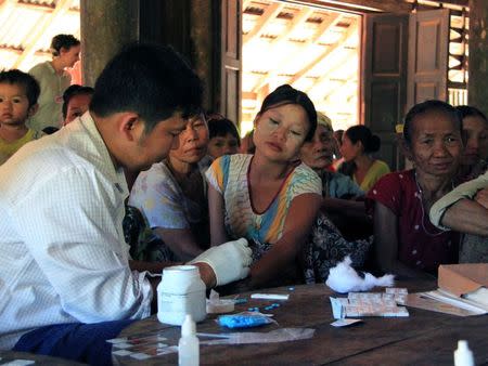 A government health worker takes a blood sample from a woman to be tested for malaria in Ta Gay Laung village hall in Hpa-An district in Kayin state, south-eastern Myanmar, November 28, 2014. REUTERS/Astrid Zweynert