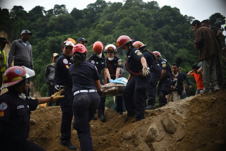 Firemen carry a body recovered from under the debris in the village of El Cambray II, in Santa Catarina Pinula municipality, some 15 km east of Guatemala City, on October 3, 2015 after a landslide