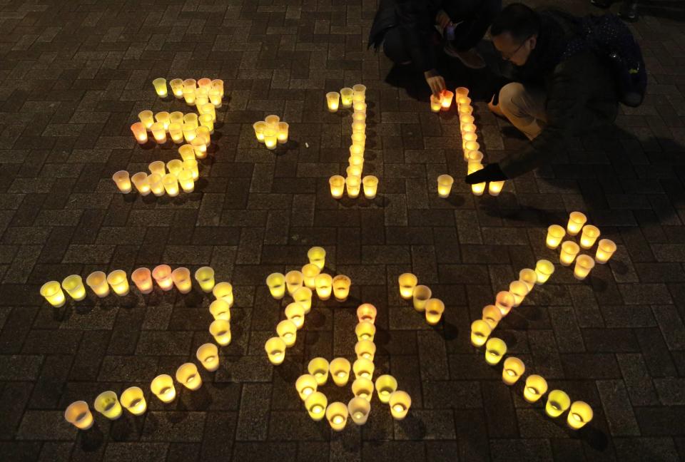 People arrange electric candles to form a message during a candle light demonstration to pay tribute to the victims of the March 11, 2011 earthquake and tsunami that killed thousands and to protest against nuclear power in Tokyo March 11, 2014, the third anniversary of the March 11, 2011 earthquake and tsunami, which triggered the world's worst nuclear crisis since Chernobyl. About 130 people participated in the demonstration, the organisers said. The message reads, "3.11, connection", which the event organiser said means, "We are always with the victims of March 11, 2011." (REUTERS/Yuya Shino)