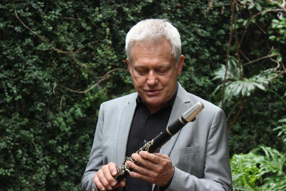 Jazz clarinetist Orange Kellin stands in the courtyard of his apartment in New Orleans' French Quarter on Thursday April, 24, 2014. Kellin played in the New Orleans Ragtime Orchestra at the first New Orleans Jazz and Heritage Festival 45 years ago in a Treme neighborhood park, and is performing with his own band at the 45th Jazz Fest. (AP Photo/Janet McConnaughey)