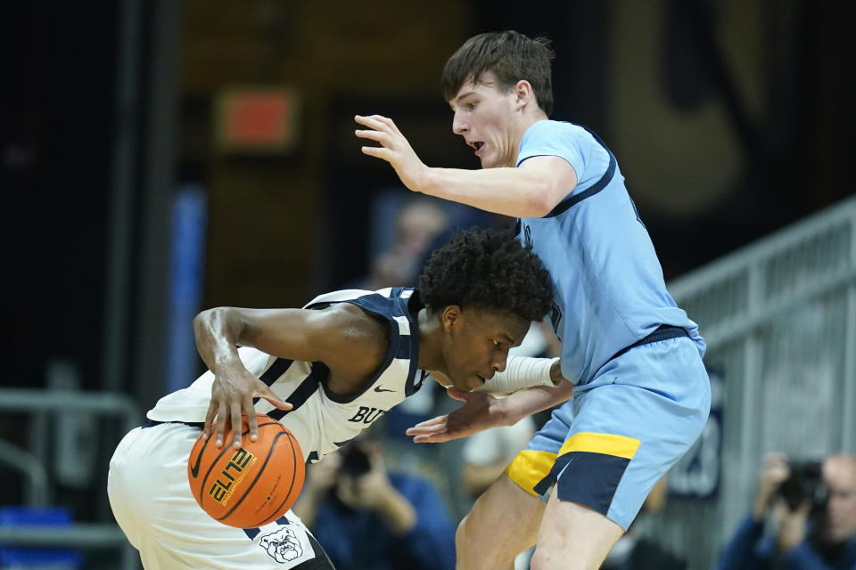 Butler's Chuck Harris, left, is defended by Marquette's Tyler Kolek (22) during the second half of an NCAA college basketball game, Saturday, Feb. 12, 2022, in Indianapolis. (AP Photo/Darron Cummings)