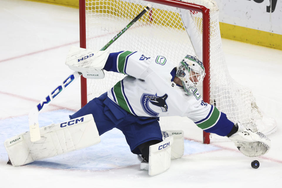 Vancouver Canucks goaltender Thatcher Demko reaches for the puck during the third period of an NHL hockey game against the Buffalo Sabres, Saturday, Jan. 13, 2024, in Buffalo, N.Y. (AP Photo/Jeffrey T. Barnes)