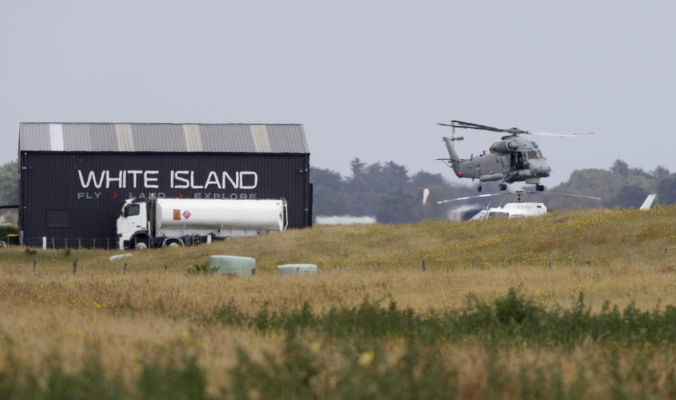 A Navy helicopter hovers at Whakatane Airport, as the recovery operation to return the victims of the Dec. 9 volcano eruption continues off the coast of Whakatane New Zealand, Friday, Dec. 13, 2019. A team of eight New Zealand military specialists landed on White Island early Friday to retrieve the bodies of victims after the Dec. 9 eruption. (AP Photo/Mark Baker)