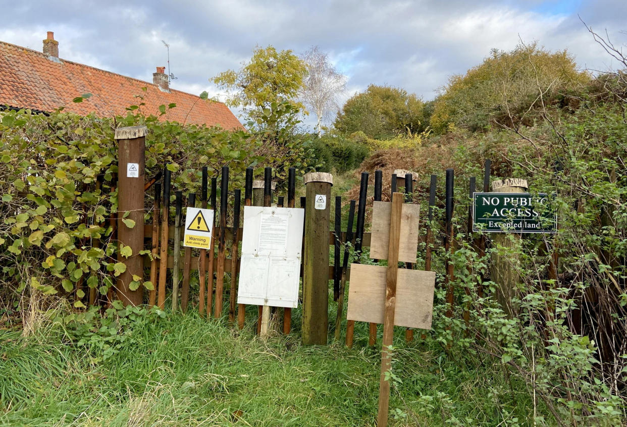 The barricade put up at the entrance to the path.  Release date – November 19, 2023.  See SWNS story SWLSbarricade.  The Nar Valley Way is one of Norfolk’s flagship footpaths, traversing an uninterrupted 33 miles of the county's ancient woodland and open green pastures. Or almost uninterrupted - Any ramblers reaching the tiny hamlet of Newton by Castle Acre will find their way impeded by an unsightly 4ft barricade made from wooden stakes.  To deter any intrepid walkers from attempting to scale the structure, the poles have even been smeared with greasy anti-climb paint, with nearby signs warning them they are being monitored on CCTV.  This rural rampart blocking around 150m of the footpath is the result of an extraordinary legal row in the village which has raged for 30 years and this week culminated in a two-day public inquiry, chaired by a government inspector.  The palisade was erected by Sine Garvie-McInally, a former Norfolk County Council (NCC) solicitor who lives in a charming cottage next to the Nar Valley Way, as a way to stop the path being used.  She claims it is has never officially been recorded as a public right of way and that this cannot now be done, retrospectively, because the route passes too close to her home and infringes her right to privacy. 