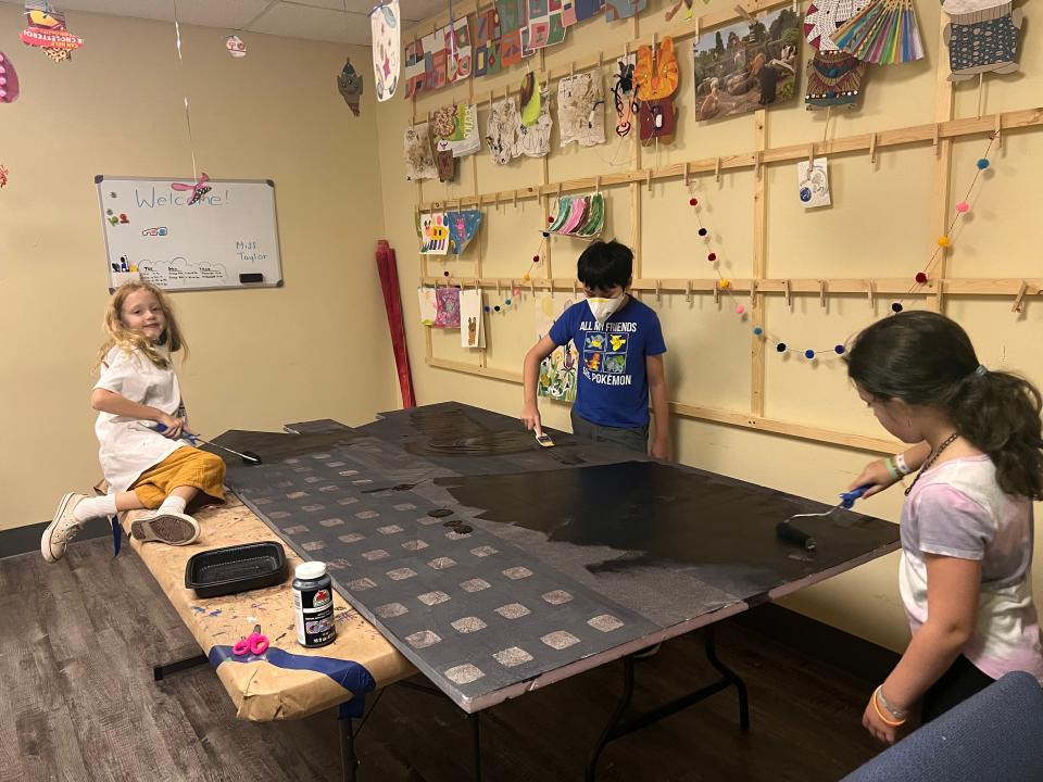 Stagecraft students paint a scene at Making Light Productions, which is presenting "Mary Poppins Jr."