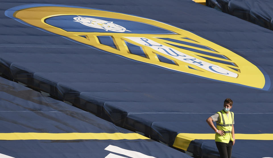 A steward wears a face mask during the English Premier League soccer match between Leeds United and Fulham at Elland Road Stadium, in Leeds, England, Saturday, Sept. 19, 2020. (Oli Scarff/Pool via AP)