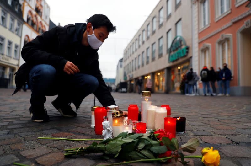 A person pays his respect at the site where a car crashed into pedestrians in Trier