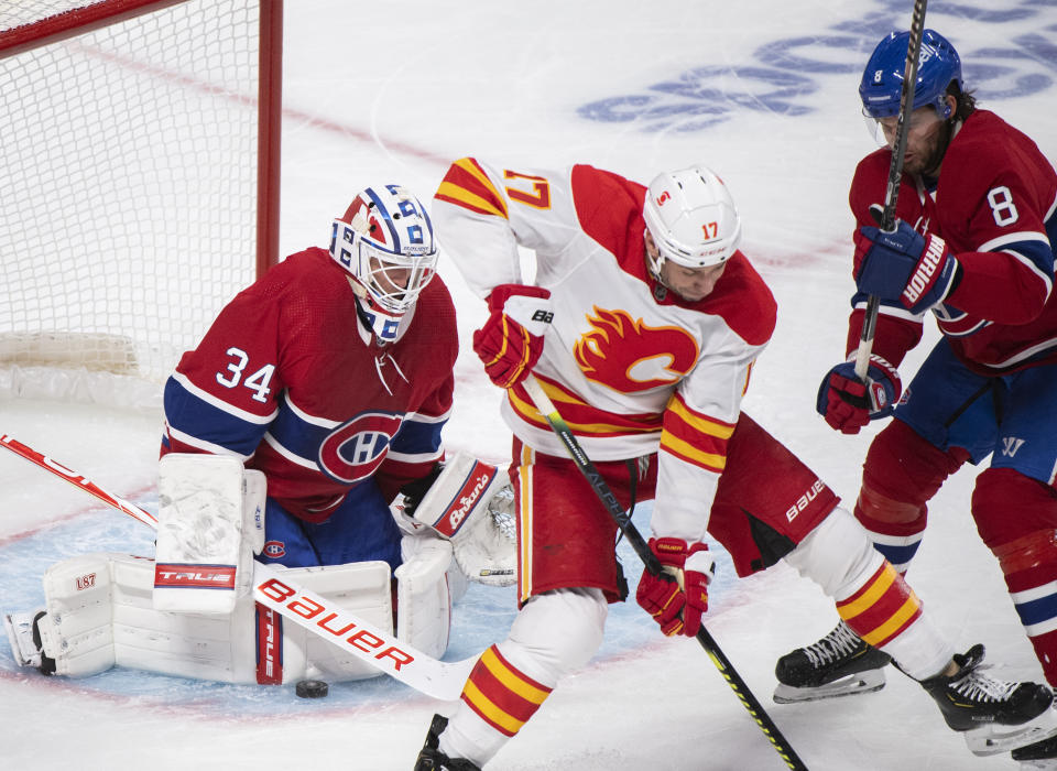 Calgary Flames' Milan Lucic (17) moves in on Montreal Canadiens goaltender Jake Allen as Canadiens' Ben Chiarot defends during second-period NHL hockey game action in Montreal, Saturday, Jan. 30, 2021. (Graham Hughes/The Canadian Press via AP)