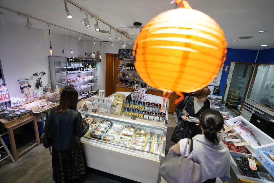 Customers look at the seafood products at Sakana Bacca, a seafood retailer, on Oct. 31, 2023, in Tokyo. Fishing communities in Fukushima feared devastating damage to their businesses from the tsunami-wrecked nuclear power plant’s ongoing discharge of treated radioactive wastewater into the sea. Instead, they're seeing increased consumer support as people eat more fish, a movement in part helped by China’s ban on Japanese seafood. (AP Photo/Eugene Hoshiko)