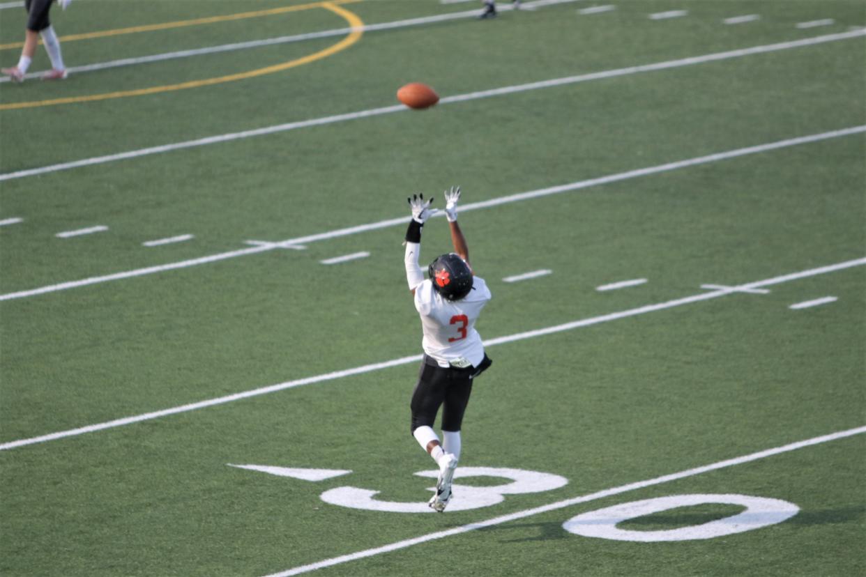 Aztec's Marcquis Henry goes up for a catch during warmups before a football game at Kirtland Central High School, Friday, Oct. 22, 2021.