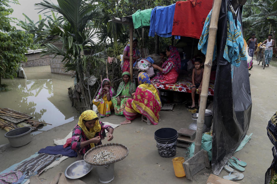 Indian flood affected villagers shelter on an embankment of river Brahmaputra in Gagolmari village, Morigaon district, Assam, India, Tuesday, July 14, 2020. Hundreds of thousands of people have been affected by floodwaters and landslides following incessant rainfall in the region. (AP Photo/Anupam Nath)