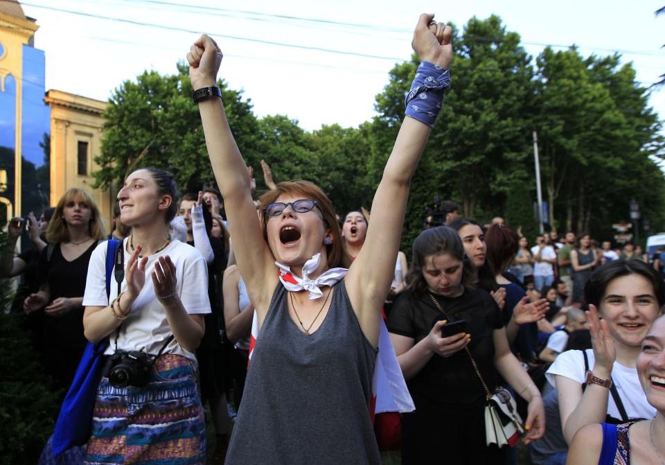 Young opposition demonstrators react while listening an orator as they gather in front of the Georgian Parliament building in Tbilisi, Georgia, Saturday, June 22, 2019. Demonstrators denounced the government Friday as overly friendly to Russia and calling for a snap parliamentary election. (AP Photo/Shakh Aivazov)