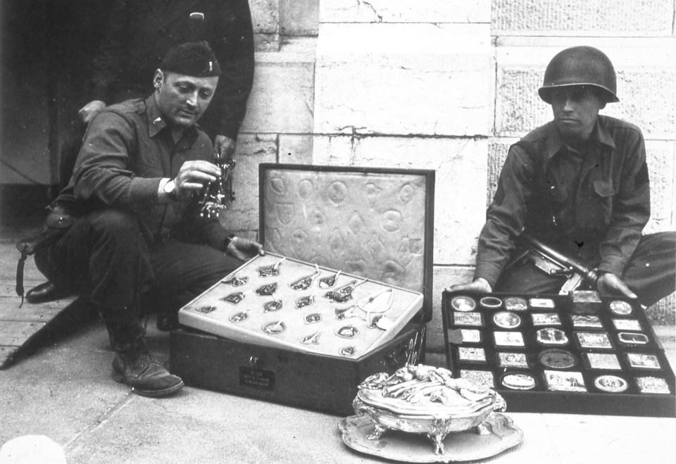 This photo provided by The Monuments Men Foundation for the Preservation of Art of Dallas, shows Monuments Man James Rorimer, left, and Sgt. Antonio Valim examining valuable art objects at Neuschwanstein Castle in Germany which were stolen from the Rothschild collection in France by the ERR and found in the castle in May of 1945. Rorimer, a curator at the Metropolitan Museum of Art before the war who eventually became its director after returning, went on to achieve great success, helping to discover where works of art looted by the Nazis were tucked away across Europe. In the upcoming movie “The Monuments Men,” Matt Damon portrays a character inspired by the real-life Rorimer, who died in 1966 at the age of 60. (AP Photo/National Archives and Records Administration)
