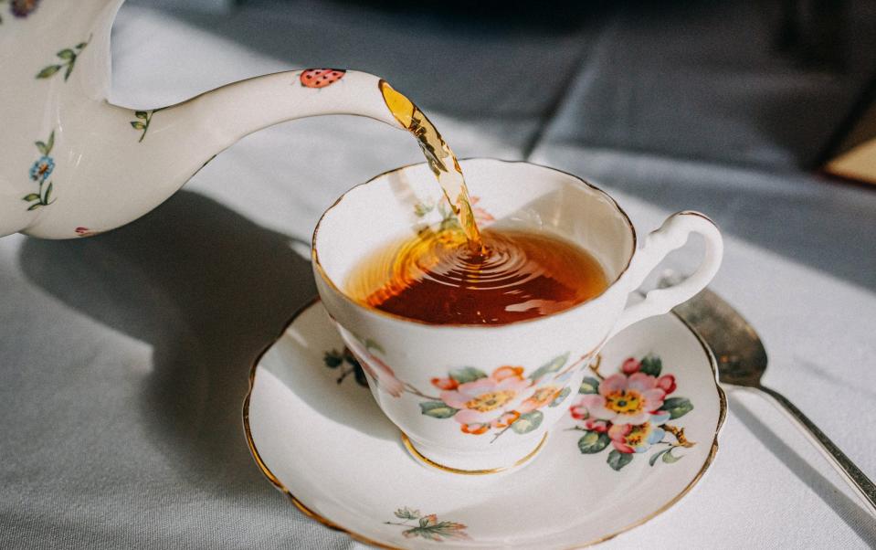 Pouring tea in to a tea cup from a vintage teapot