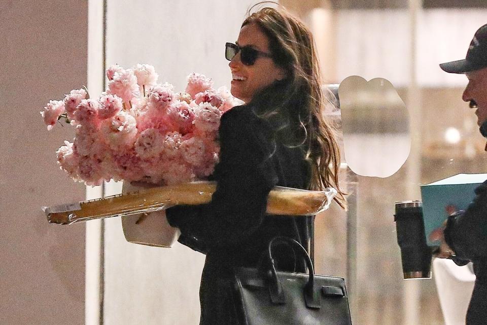 Brad Pitt's girlfriend Ines De Ramon receives flowers at her work office and looks happy as she heads out from work carrying the bouquet on Valentines day!