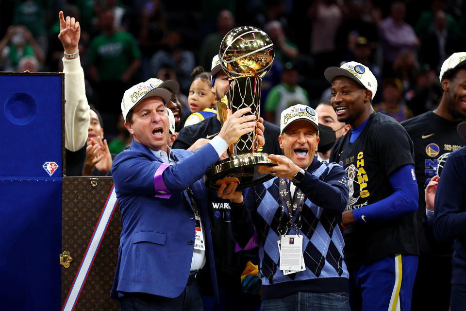 BOSTON, MASSACHUSETTS - JUNE 16: Owners Joe Lacob and Peter Guber of the Golden State Warriors raise the Larry O'Brien Championship Trophy after defeating the Boston Celtics 103-90 in Game Six of the 2022 NBA Finals at TD Garden on June 16, 2022 in Boston, Massachusetts. NOTE TO USER: User expressly acknowledges and agrees that, by downloading and/or using this photograph, User is consenting to the terms and conditions of the Getty Images License Agreement. (Photo by Elsa/Getty Images)