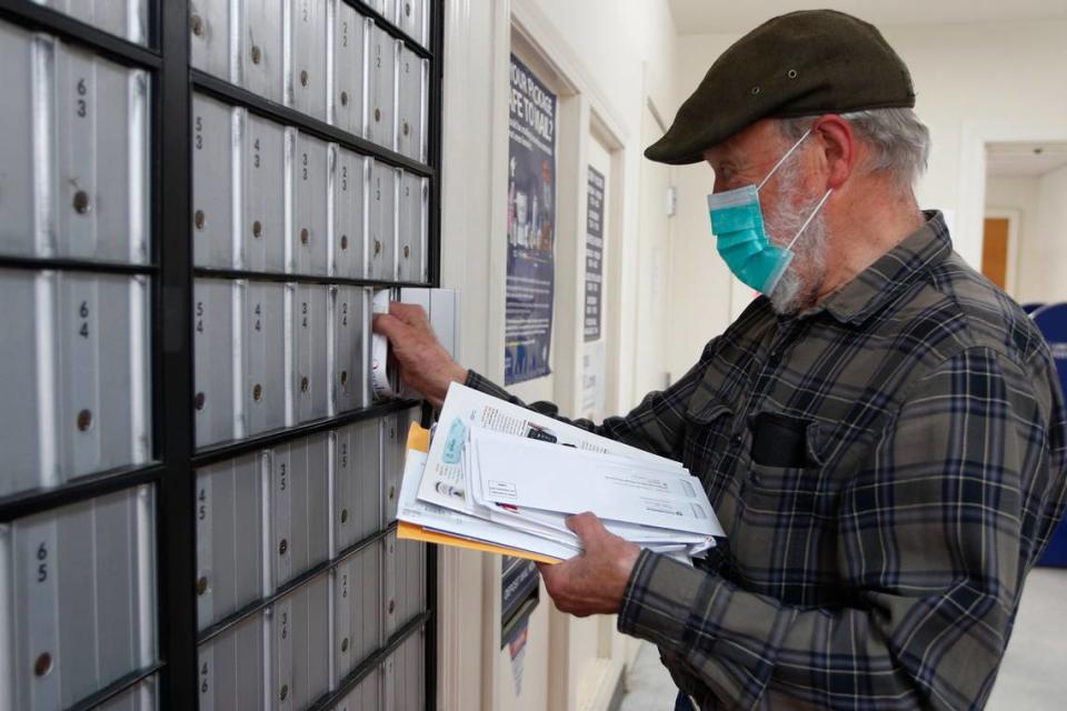 Vaino Kola picks up his mail at the post office on Deer Isle, Maine. Many residents call the postal service essential to their communities, but the federal agency is in trouble.