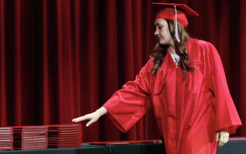 A student picks up her diploma during a graduation ceremony on May 6, 2020 in Bradley, Illinois. (Photo: KAMIL KRZACZYNSKI / AFP)