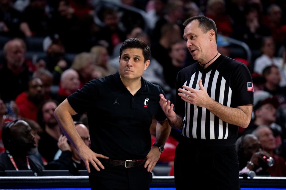 Cincinnati head coach Wes Miller stands next to a referee in the second half of the basketball game between Cincinnati Bearcats and Stetson Hatters at Fifth Third Arena in Cincinnati on Friday, Dec. 22, 2023.