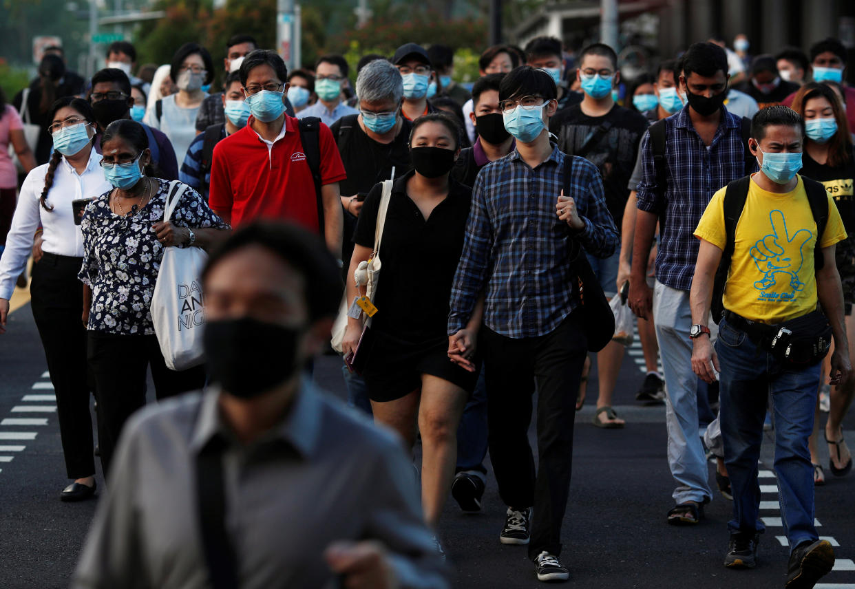 People cross a street during morning peak hour commute amid the coronavirus disease outbreak in Singapore on 3 June, 2020. (PHOTO: Reuters)