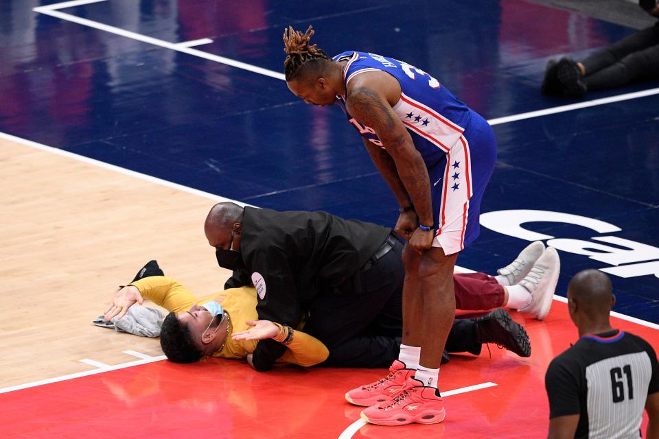 Philadelphia 76ers center Dwight Howard watches as a fan who ran onto the court is restrained by security personnel during the second half of Monday's game.