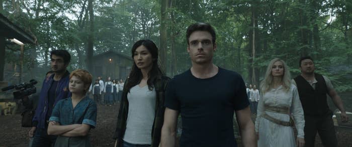 The Eternals standing in a wooded area