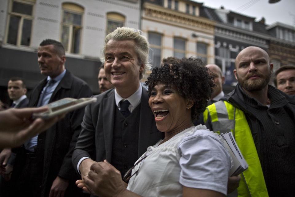 Firebrand anti-Islam lawmaker Geert Wilders, laughs with a supporter during a campaign stop in Heerlen, Netherlands, Saturday, March 11, 2017. The Dutch electorate go to the polls for parliamentary elections of March 15. (AP Photo/Muhammed Muheisen)